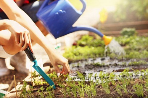 Garden maintenance worker in a Carshalton garden, smiling while pruning a shrub